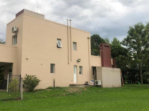 un gran edificio blanco con un campo verde delante de él en Casa Pilar en Yerba Buena