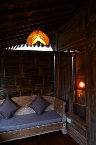 a bedroom with a bed and a chandelier at Lastana Suite Joglo Ubud in Ubud