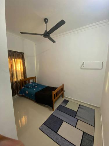 Homestay Midan Alor Setar في ألور سيتار: غرفة نوم بسرير ومروحة سقف