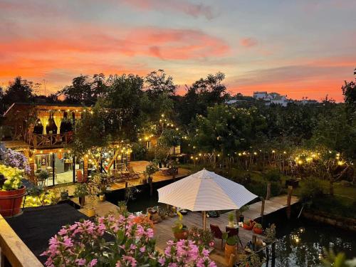 Blick auf einen Garten mit einem weißen Zelt und Lichtern in der Unterkunft HomeTa Homestay in Bảo Lộc