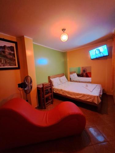 a bedroom with two beds and a tv on the wall at Hospedaje Leo in Lima