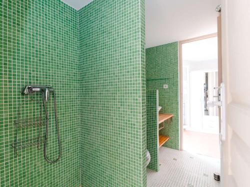 uma casa de banho com paredes em azulejo verde e um chuveiro em Villa Fleury-Saint-Pierre-la-Mer, 4 pièces, 6 personnes - FR-1-409-188 em Fleury