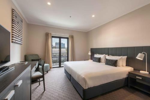 een hotelkamer met een bed, een bureau en een raam bij Frome Apartments in Adelaide