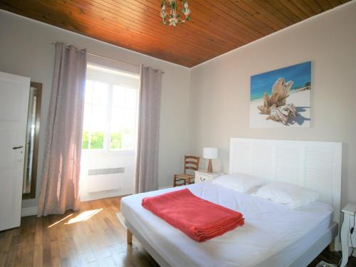 une chambre avec un lit avec une couverture rouge dessus dans l'établissement Maison à La Tranche-sur-Mer : Plage et Commerces à Proximité, Jardin, 3 Chambres, Parking - FR-1-22-343, à La Tranche-sur-Mer