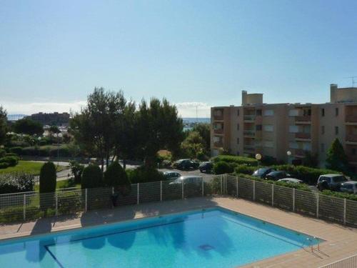 une grande piscine bleue à côté d'un parking dans l'établissement Studio cosy avec terrasse, piscine, tennis, Wi-Fi - Accès direct plage - Bormes-les-Mimosas - FR-1-251-560, à Bormes-les-Mimosas