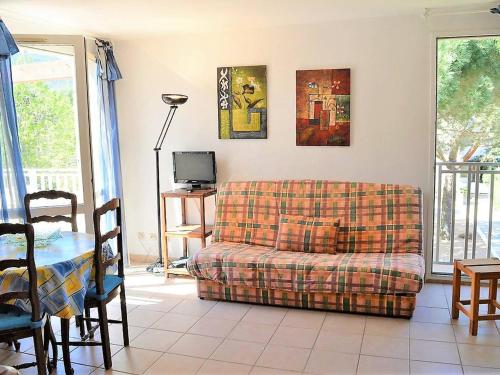 un salon avec un canapé et une table dans l'établissement Appartement Duplex avec Terrasse, 2 Chambres, Parking Privé à 2 Min de la Plage - FR-1-251-569, au Lavandou