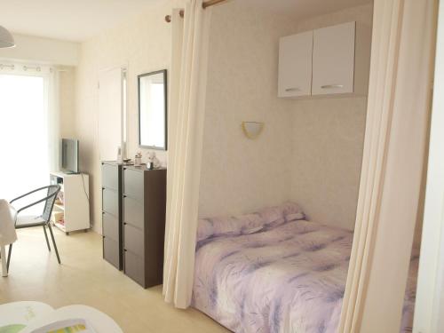 une petite chambre avec un lit dans une pièce dans l'établissement Charmant studio, proche plage et commerces, balcon fermé, quartier calme, parking privé - FR-1-323-422, à Saint-Jean-de-Monts