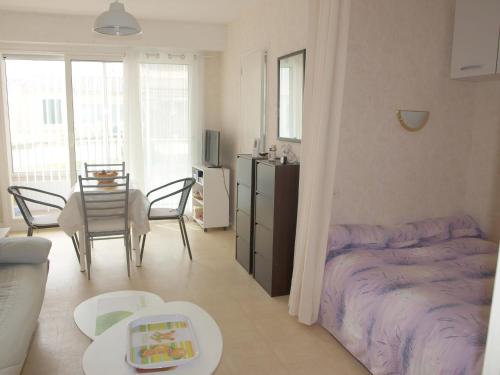 un salon avec un lit et une table dans l'établissement Charmant studio, proche plage et commerces, balcon fermé, quartier calme, parking privé - FR-1-323-422, à Saint-Jean-de-Monts