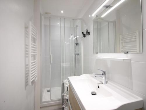 une salle de bain blanche avec un lavabo et une douche dans l'établissement Appartement T1 confortable au Mont-Dore pour 2 personnes - FR-1-415-151, à Le Mont-Dore
