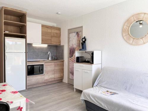Cette petite chambre dispose d'une cuisine et d'un réfrigérateur blanc. dans l'établissement Appartement rénové, 2 pièces, climatisé, garage, balcon, à 350m de la plage - Bormes-les-Mimosas - FR-1-251-526, à Bormes-les-Mimosas