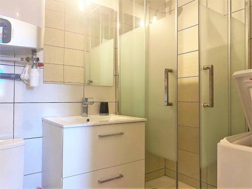 une salle de bain blanche avec un lavabo et une douche dans l'établissement Appartement rénové, 2 pièces, climatisé, garage, balcon, à 350m de la plage - Bormes-les-Mimosas - FR-1-251-526, à Bormes-les-Mimosas