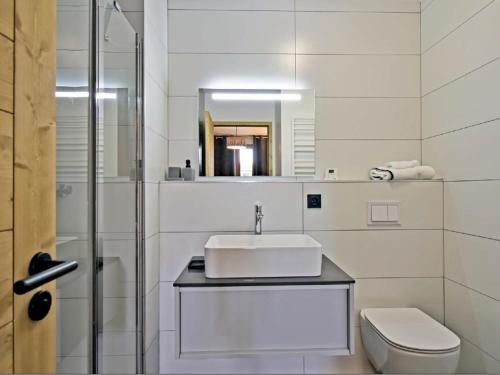 een witte badkamer met een wastafel en een toilet bij Appartement Huez, 2 pièces, 2 personnes - FR-1-645-60 in Huez