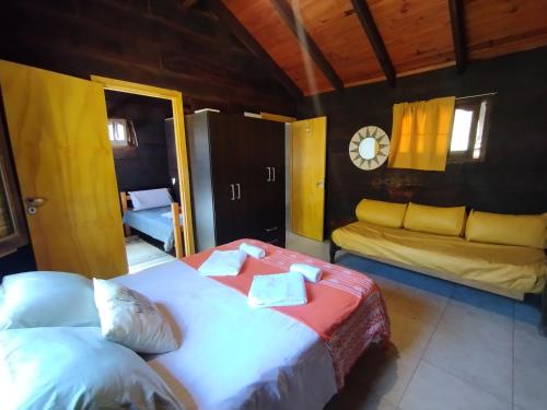 鲁米帕尔镇La Cabañita Córdoba的一间卧室配有两张床和一张沙发。