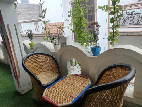 a chair sitting on a balcony with plants at Manavi Home Stay in Mathura