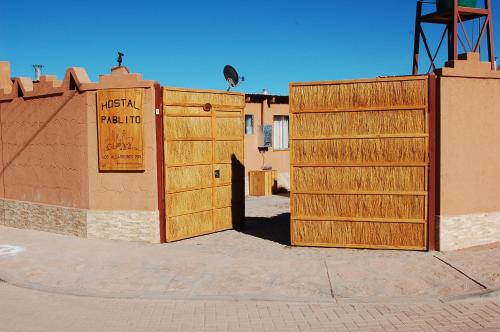 a brick building with a sign on the side of it at Hostal Pablito in San Pedro de Atacama