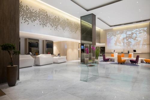 a lobby of a hotel with couches and chairs at Novotel Makassar Grand Shayla in Makassar