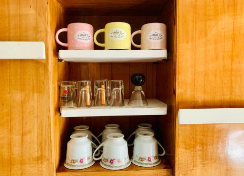 a row of coffee mugs and cups on shelves at Ankara Merkezde Piyanolu Daire in Ankara
