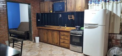 a kitchen with a white refrigerator and a sink at Paz alojamiento in Jardín América