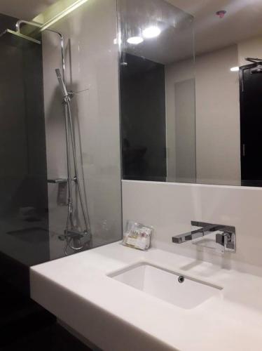 a white bathroom with a sink and a mirror at MAXX HOTEL MAKATI by MAXIHOME LAND in Manila
