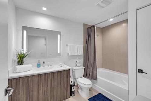 a bathroom with a sink and a toilet and a bath tub at Modern 2 Bed in the Heart of Doral Free Parking in Hialeah Gardens