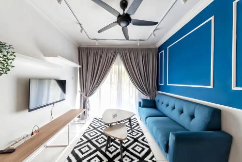 a living room with a blue couch and a ceiling fan at Emerald Avenue Cameron Highlands in Brinchang