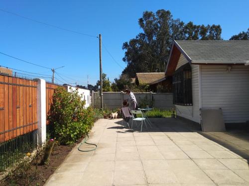 a person sitting on a chair in a backyard at Acogedora casa en Algarrobo in San Antonio