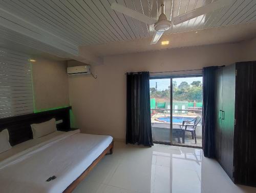 een slaapkamer met een bed en uitzicht op een zwembad bij Hotel Oneness Palace in Mahabaleshwar