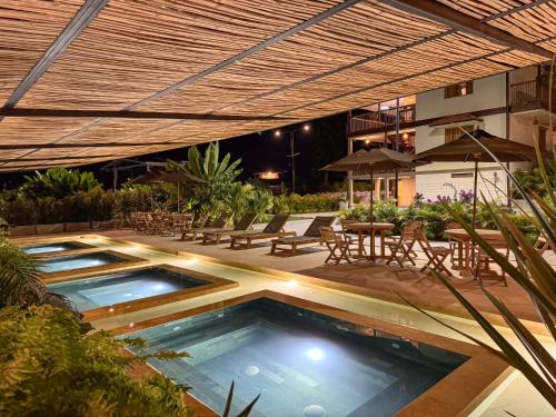 een zwembad met een patio met tafels en stoelen bij Finca del Café - Casa Bourbon in Santa Rosa de Cabal