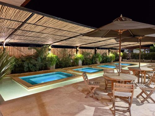 a pool with tables and chairs and an umbrella at Finca del Café - Casa Bourbon in Santa Rosa de Cabal