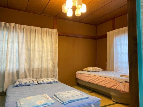 a bedroom with two beds and a chandelier at Mason 2 ,direct to Disney,Narita AP, Haneda AP,Asakusa,Sky Tree Tower, Ueno Ueno in Kamagaya
