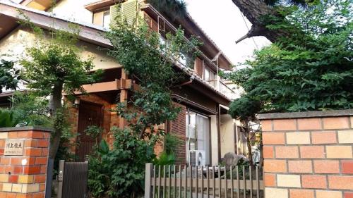 a brick house with a fence in front of it at Mason 2 ,direct to Disney,Narita AP, Haneda AP,Asakusa,Sky Tree Tower, Ueno Ueno in Kamagaya