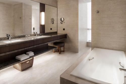 a bathroom with two sinks and a bath tub at Courtyard by Marriott Taipei in Taipei