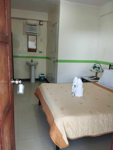 um quarto com uma cama, um lavatório e uma casa de banho em jazmine hotel em San José