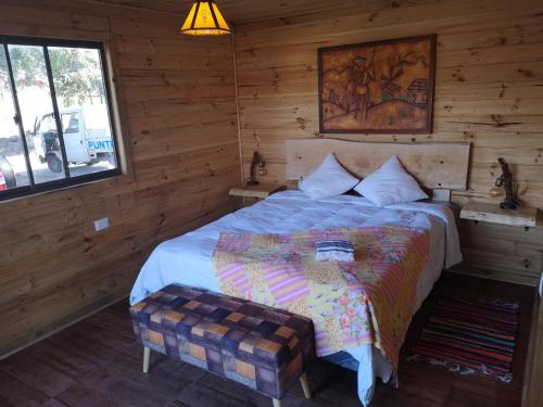a bedroom with a bed with a table in it at Rukawe Quillon in Quillón