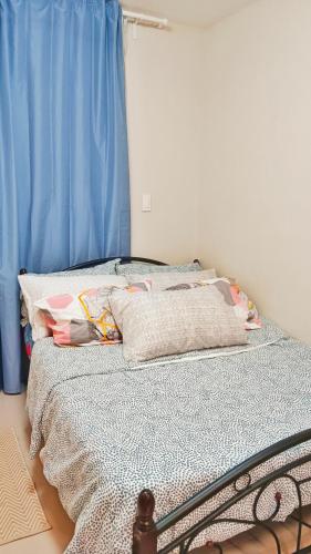 a bedroom with a bed with a blue curtain at Private studio unit with balcony near the beaches in Lapu Lapu City