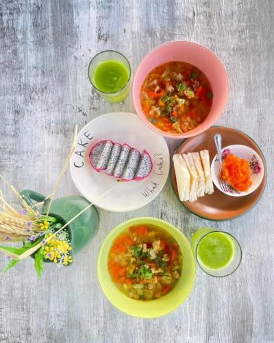 a table with plates of food and bowls of soup at The 99 Cottage (บ้านทุ่งบางปลาม้า) in Suphan Buri