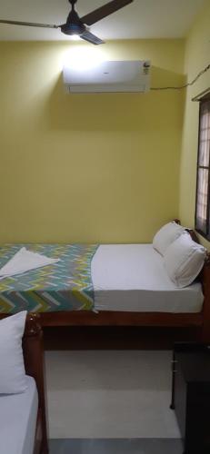 a bedroom with a bed and a ceiling fan at Varadhar Guest House in Kanchipuram