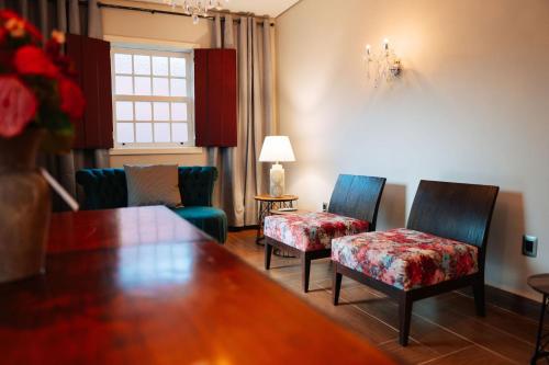 a living room with two chairs and a table at Pousada Pequena Tiradentes in Tiradentes