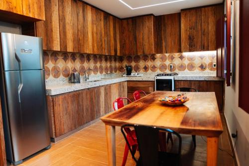 a kitchen with a wooden table and a refrigerator at Pousada Pequena Tiradentes in Tiradentes