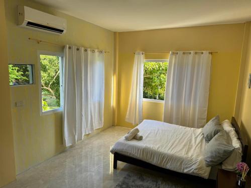a bedroom with a white bed and two windows at Paradise panglao pool villa 