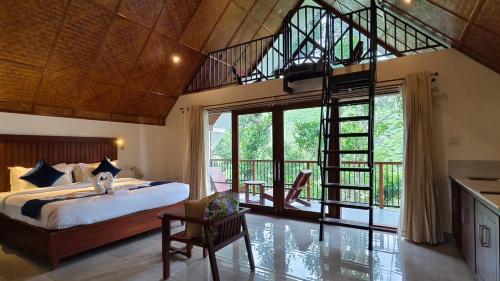 a bedroom with a bed and a large window at Lush Acres in Thekkady