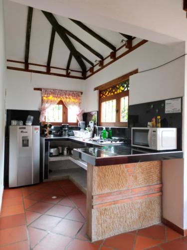 a kitchen with black counter tops and appliances at Cabañas Villa Encanto in Villa de Leyva