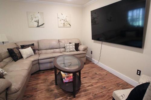 a living room with a couch and a large flat screen tv at Cozy Aggieland Vacay in Bryan