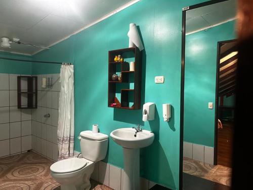 Baño azul con aseo y lavamanos en The Monkey Trail Hostel en Drake