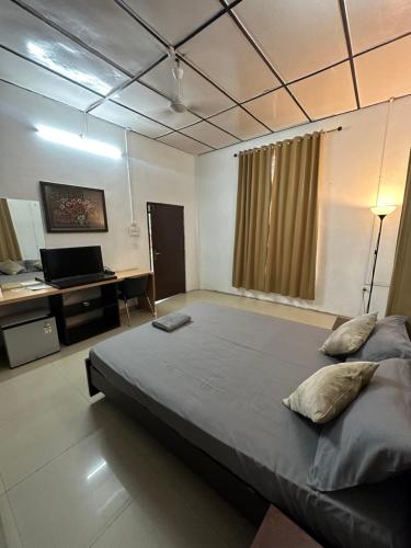 1 dormitorio con 1 cama grande y escritorio en Premier Lodge, en Dimāpur