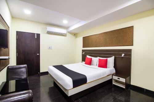 um quarto de hotel com uma cama e uma cadeira em Capital O Sri Navya Grand Near Nexus Hyderabad em Lingampalli