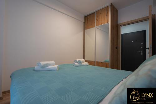 a bedroom with a blue bed with towels on it at Lynx Apartment in Mavrovo