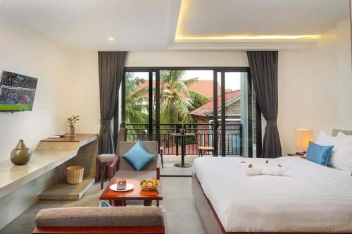 1 dormitorio con 1 cama grande y balcón en Model Temple Villa, en Siem Reap