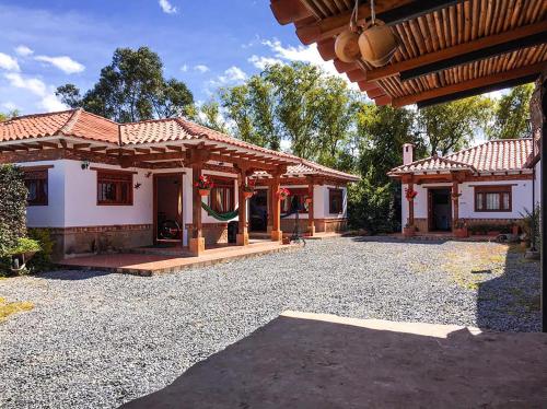 a house with a pavilion in a gravel yard at Cabañas Villa Encanto in Villa de Leyva