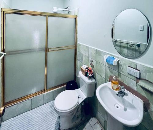 a bathroom with a shower and a toilet and a sink at Amplia, independiente y segura vivienda de 2 habitaciones in Machala